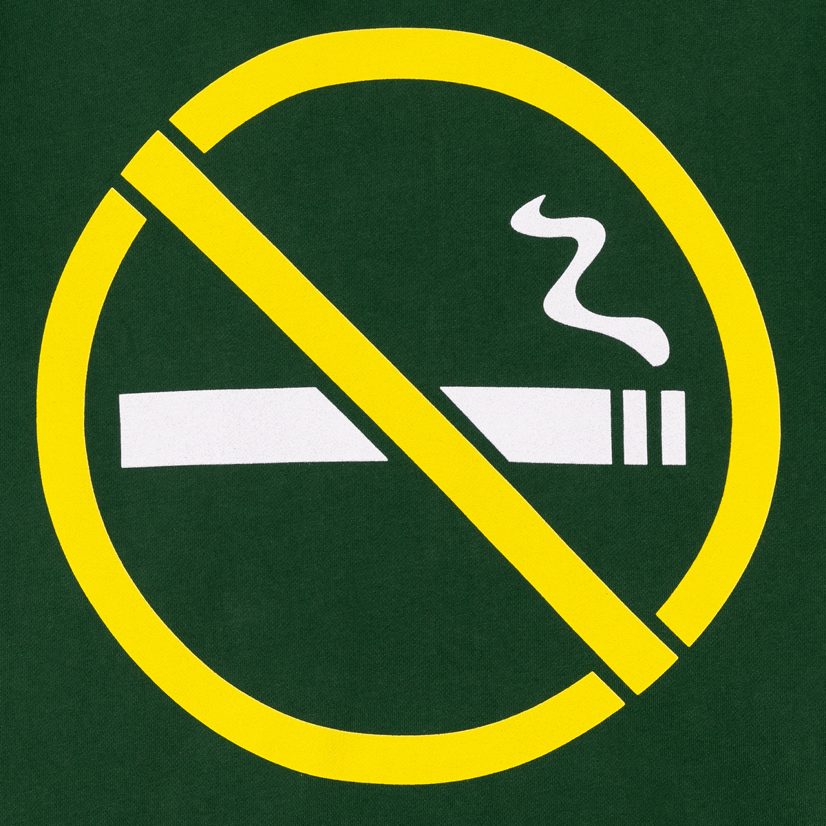 A circular yellow no-smoking symbol with a diagonal slash over a white cigarette icon, centered on a dark green background.
