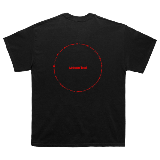Back of a black short-sleeve T-shirt showcasing a red Malcolm Todd "Do That Again" circular graphic.