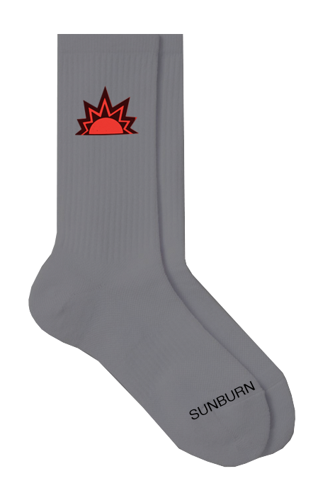 Side view of charcoal grey socks displaying a sun design at the upper ankle and the word ‘sunburn’ in black text positioned across the foot