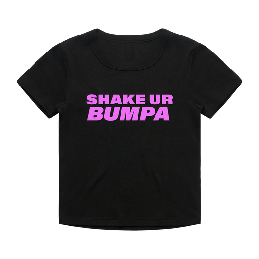 A black short-sleeve scoop neck t-shirt with the phrase 'SHAKE UR BUMPA' printed in bold pink letters across the chest.