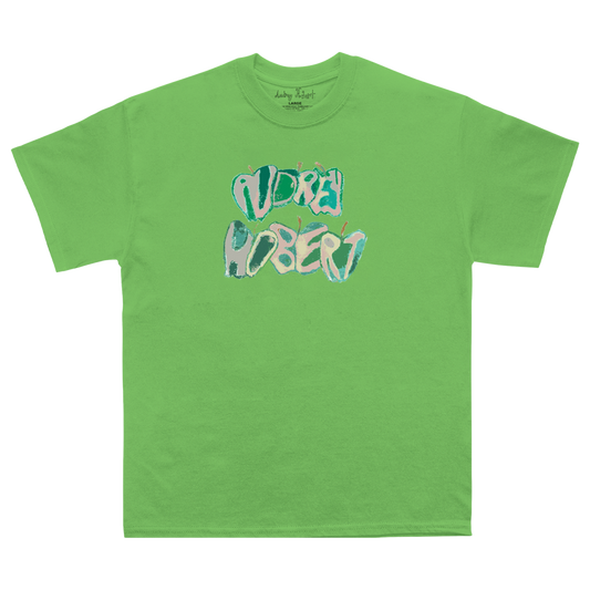 A bright green crewneck t-shirt featuring a stylized graphic print of the text 'AUDREYHOBERT' in a bubbly, layered font with teal, light blue, and pink colors, displayed on a clean white background.