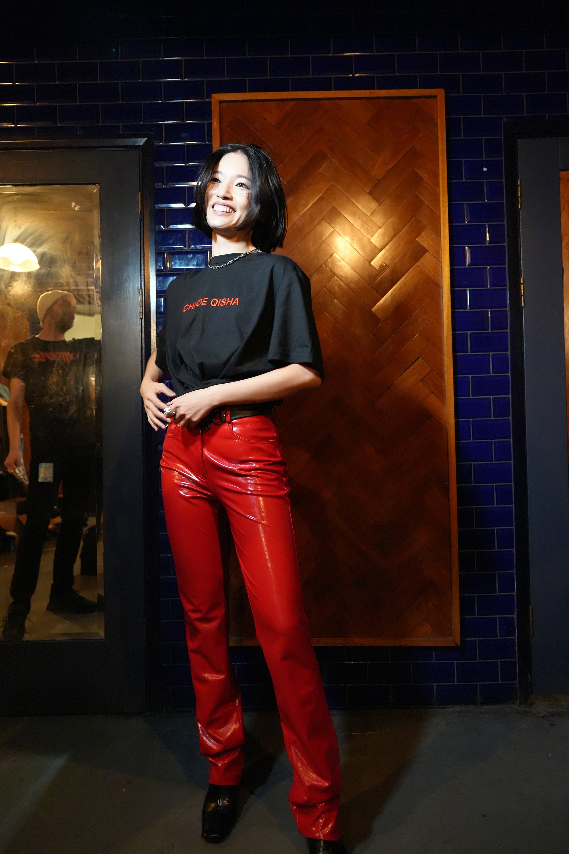 Image of Chloe Qisha wearing a black short-sleeve t-shirt with red Chloe Qisha text across the front