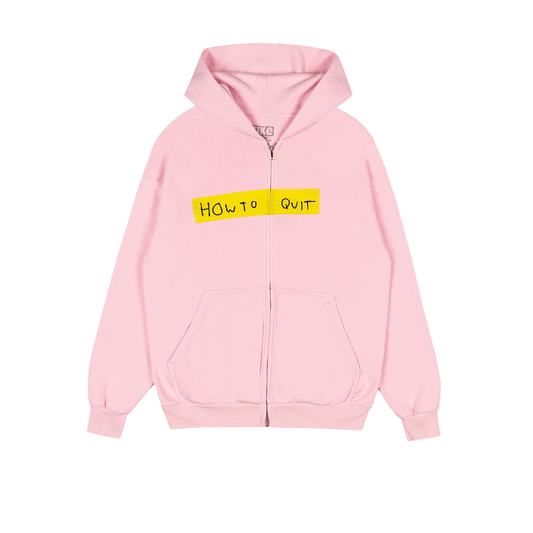 A light pink Dominic Fike zip-up hoodie with a yellow rectangular graphic on the chest containing the handwritten text 'HOW TO QUIT' in black. The hoodie features a front zipper, a kangaroo pocket, and ribbed cuffs and hem.
