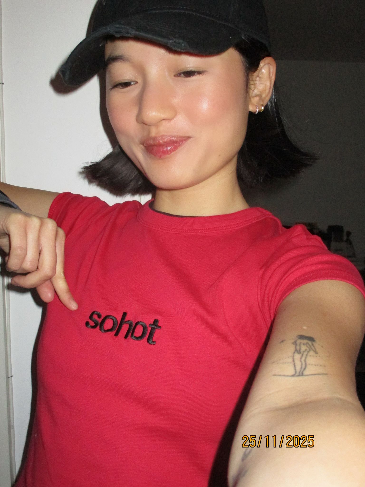 Chloe Qisha wearing a red short-sleeve t-shirt with black 'so hot' text across the front