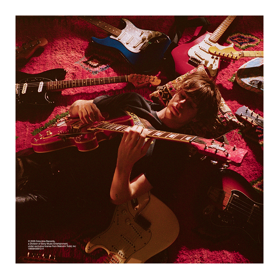 Malcolm Todd – Do That Again standard CD insert featuring Malcolm lying on the floor surrounded by guitars while playing one
