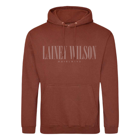 A rust-colored cotton hoodie featuring a front pocket and drawstrings with ’lainey wilson’ printed across the chest in matching tone.